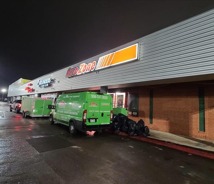 SERVPRO 24/7 - image of green SERVPRO vehicles in front of store
